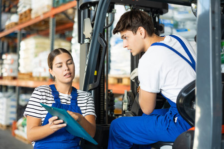 Young woman and young guy working on loader check documents
