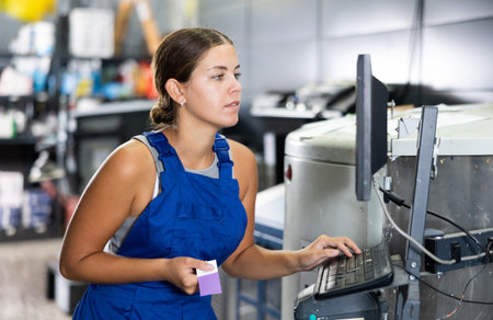 Experienced woman seller using technical computer and mixing machine in hardware storeの写真素材