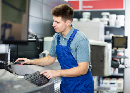 Man worker operating computerised machine to mix paint in paint shopの写真素材