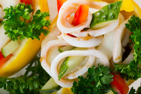 Tropical salad with squids served in lemon with cucumbers and pepperの写真素材