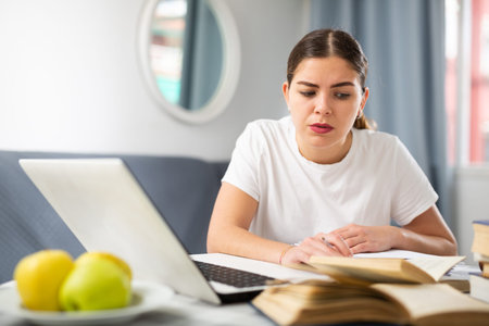 Young tired woman studying during online courses