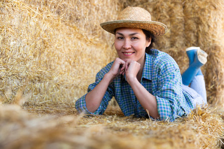Woman posing at hay storage on farmの写真素材