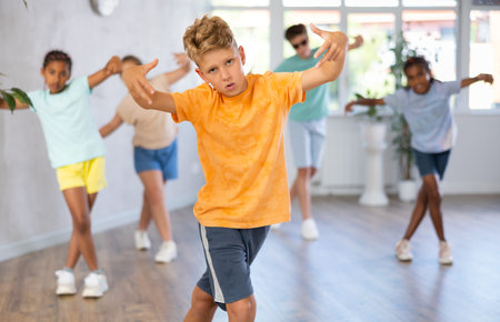 Boy perform choreographic exercises and teach energetic social dance waacking with friends