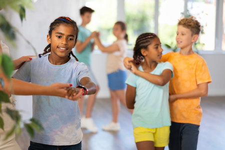 Cheerful preteen african american boy dancing with female instructorの写真素材