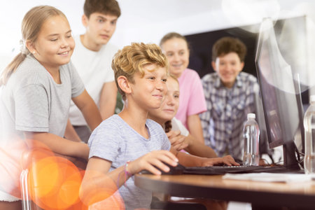 Group of students working at computer in classroom