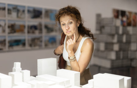 Middle-aged woman looking at building models in museum