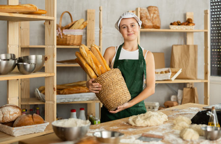 Teenage girl with basket of baguettes in bakery