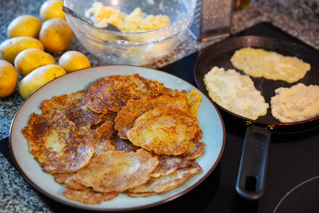 Preparation of potato pancakes on frying pan