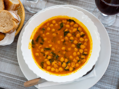Stewed curried chickpeas with spinach on white plateの写真素材