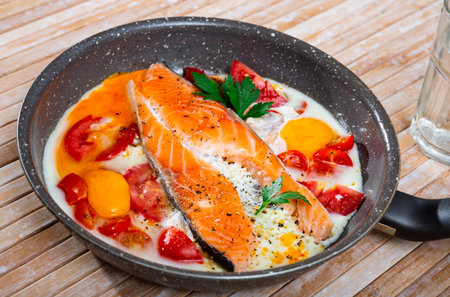 Fried eggs with salmon and cherry tomatoの写真素材