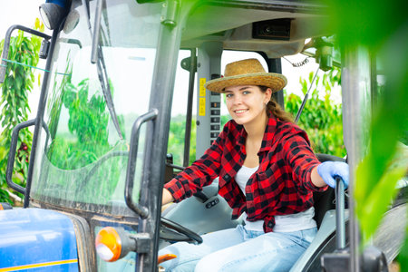 Portrait of female worker working on tractorの写真素材