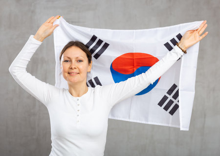 Happy smiling woman proudly displaying south korean flagの写真素材