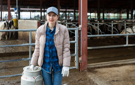 Portrait of woman dairy farm worker with milk canの写真素材