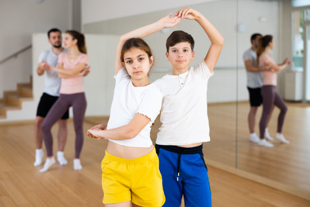 Siblings practicing active dance in pairsの写真素材