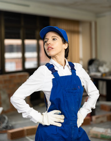 Woman construction worker posing inside house under renovationの写真素材