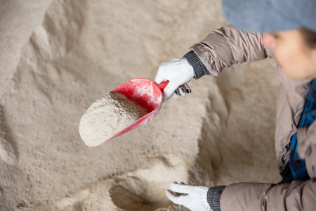Woman farmer holding scoop with corn flourの写真素材