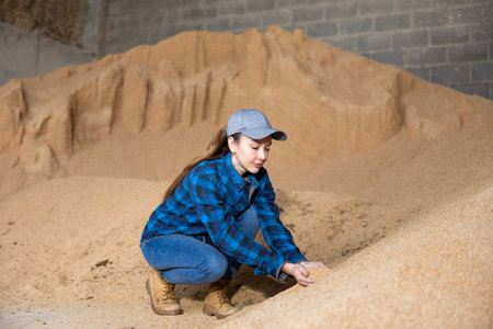 Farmer holding a handful of soybean husks in an animal feed warehouse