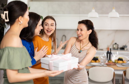Group of women greeting each other and giving giftの写真素材