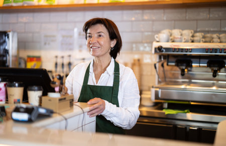 Elderly woman at cash register in cafeのeditorial素材
