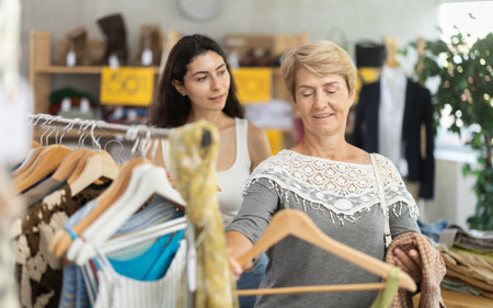 Young woman together with mature woman standing in store at summer sale