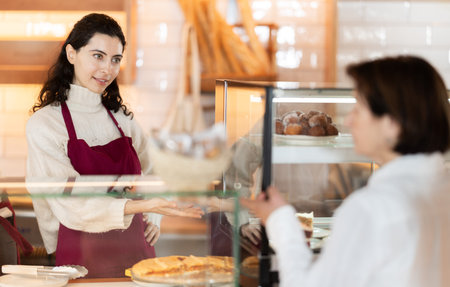 In bakery girl talk to customer, answers questions and recommends fresh products
