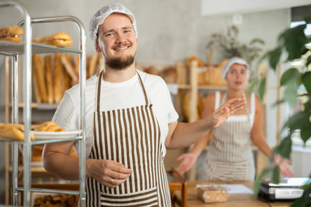 In bakery, male employee during interaction with female bossの写真素材