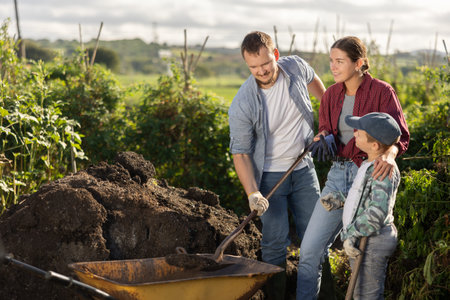 Family of farmers working with compost