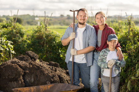 Man woman and boy at wheelbarrow with soilの写真素材