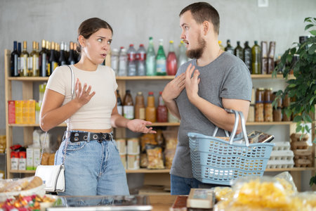 Man and woman quarrel in supermarket - they shout at each otherの写真素材