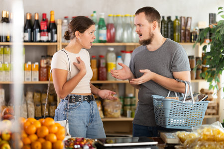 Family quarrel between a husband and wife in grocery supermarketの写真素材