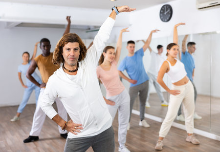 Group of women and men training sport dance in modern studio