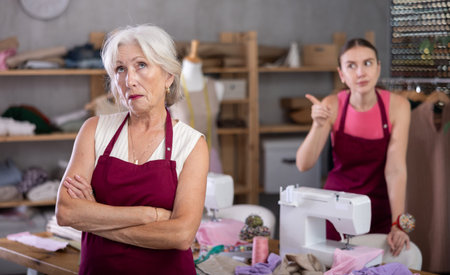 Woman head of sewing workshop interacts with her subordinate senior female seamstress.