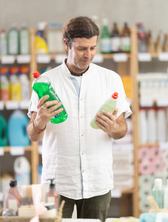 Man view trademark sign on label, pick eco friendly dishwashing detergentのeditorial素材