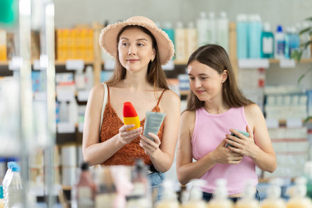 Woman with daughter choosing sunscreen in pharmacyのeditorial素材