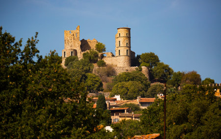 Ruins of Grimaud castle on hill dominating houses of village, France