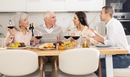 Senior couple with grown son and daughter-in-law enjoying dinner
