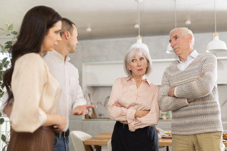 Adult son introducing girlfriend to disapproving senior parentsの写真素材