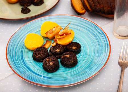 Fried blood sausage with potatoes served at plate
