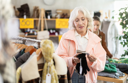 Elderly woman choosing gloves in clothing storeの写真素材