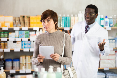 Woman choosing prescription medications with help of pharmacistの写真素材