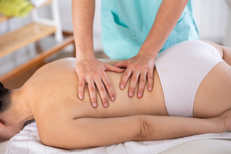 Woman having back massage close up in spa room