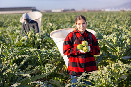 Portrait of a young woman farmer with artichokes