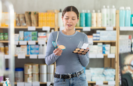 Young girl choosing cosmetics in chemists shopの写真素材
