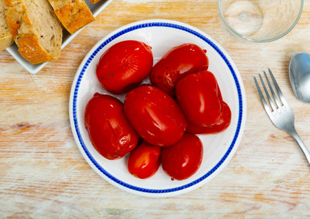 White plate with pickled tomatoes on tableの写真素材