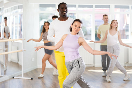 Woman with man dancing waltz in couple during lesson at studio