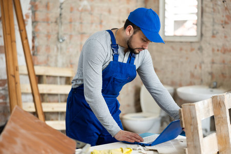Man with laptop on indoor construction site