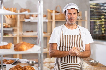 Portrait of professional male baker in uniform in bakeryの写真素材