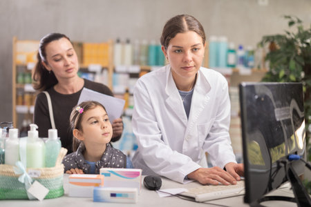 Pharmacist recommending medicines to mom with child at drugstore counterの写真素材