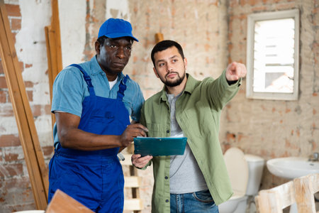 Male worker man is clarifying details of work from foreman
