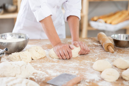 Baker kneading dough on a flour-dusted countertop
